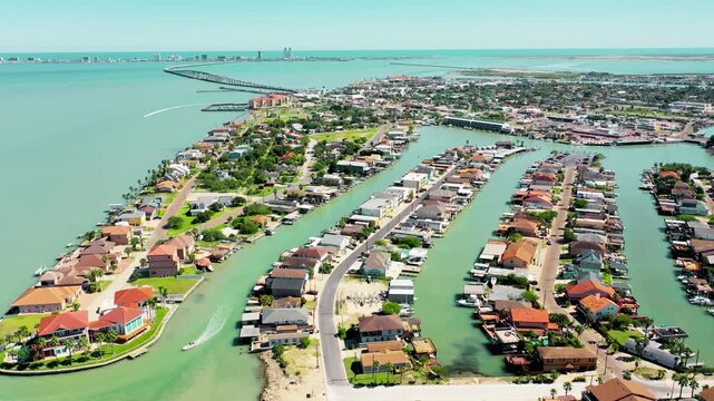 A գեղեցous 4K aerial drone video capturing the scenic coastal views of Port Isabel, featuring the calm waters of the Laguna Madre, the iconic Queen Isabella Causeway, and South Padre Island in the bac
