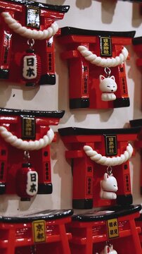 Traditional Japanese tourist souvenirs and gifts from Kyoto, Kansai, Japan, with daruma figures, kitsune fox, tengu mask, fridge magnets, toys figurines, key ring keychain, in a local vendor gift shop