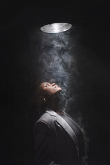 Portrait of authentic young african girl in spot light in smog. Poster with copy space.