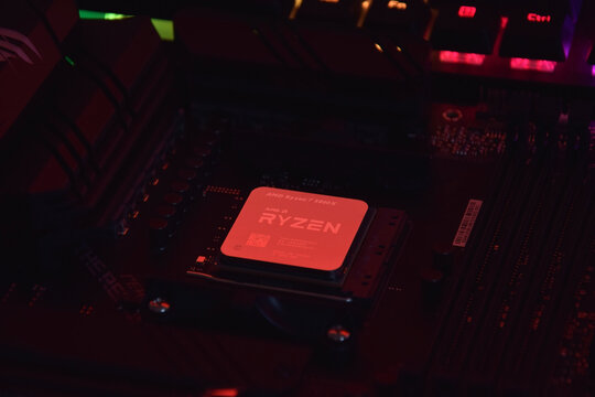 A close-up of an AMD Ryzen 7 5800X processor in a packaging box with backlit keyboards in the background.