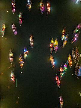 Aerial view of boats lit with colorful lanterns drift serenely on the dark waters of the river, Hoi An, Vietnam.