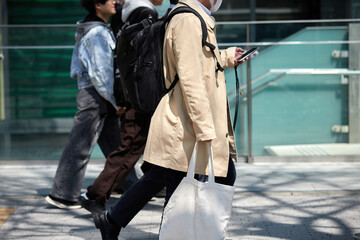 Fototapeta premium 昼の都市の繁華街で歩く中年男性サラリーマンと人々の姿