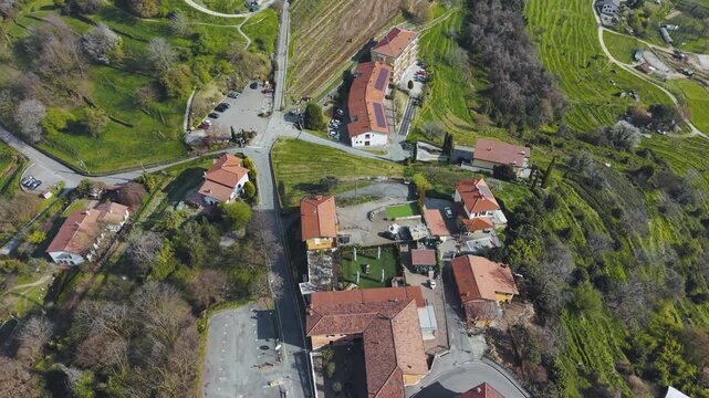 Cinematic Drone Descending Shot from High Altitude to Village of Montevecchia with Terracotta Rooftops Vineyards and Green Hillside Lombardy Italy 4K