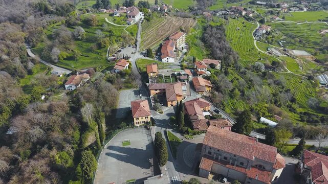 Drone Forward Flight Over Hilltop Village of Montevecchia with Terracotta Rooftops Vineyards Winding Roads and Green Countryside Lombardy Italy Spring 4K