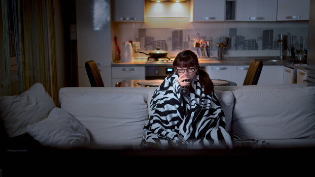 Woman Watching TV Alone Wrapped in Blanket on Couch at Night, have fun and enjoy