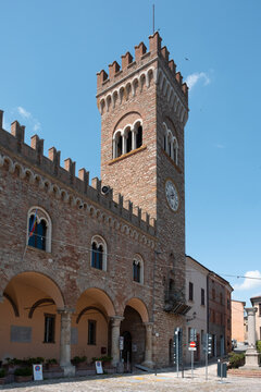View of an ancient stone tower rises majestically against a clear blue sky, its crenellated crown a testament to history in Bertinoro, Italia.