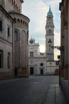 View of weathered brick buildings rise against a soft sky, casting shadows on the cobblestone streets, capturing the essence of ancient charm, Parma, Emilia Romagna, Italy.