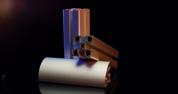 Arrangement of silver industrial aluminum t-slot extrusion profiles with cinematic lighting on black background
