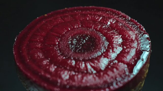 Sliced beetroot cross-section background with a narrow wet highlight tracing concentric burgundy rings