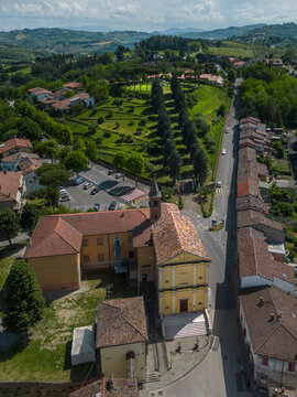 Aerial view of the church with red roof and yellow walls stands out against the green landscape, Sorrivoli, Emilia Romagna, Italia.