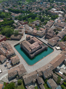 Aerial view of the imposing Rocca Sanvitale, a fortress surrounded by a moat reflecting the sky, stands as a testament to history, Parma, Emilia Romagna, Italy.