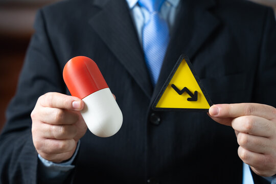 Medicinal capsule and arrow pointing down. Decreasing drug effectiveness and limited popularity. Antibiotics shortage and supply decline. Pharmaceutical market crisis and resistance problem