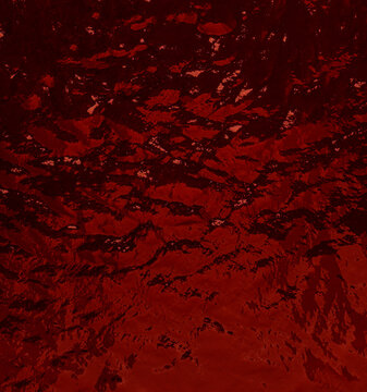 Red liquid surface creating abstract rippling waves texture