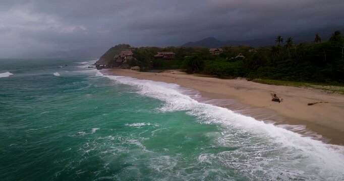 Drone flight over breaking waves on beach towards resorts on Rio Piedras bank