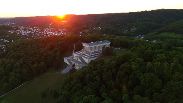 Aerial drone view of the Walhalla memorial near Regensburg, Germany. This neoclassical temple on Braeuberg hill overlooks the Danube river in Lower Bavaria during a golden summer sunset
