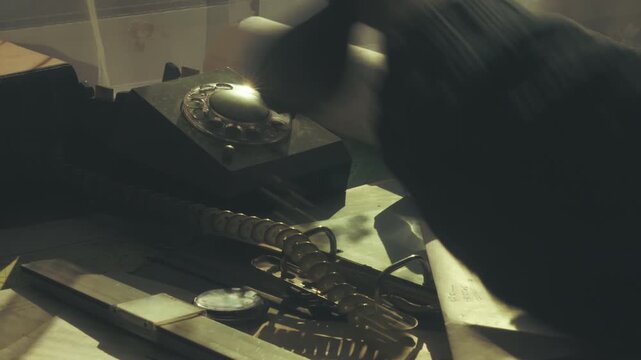 Cinematic shot of a person smoking cigarettei in low-lit office hesitating before hanging up a vintage telephone. Themes of indecision, stress and tension.
