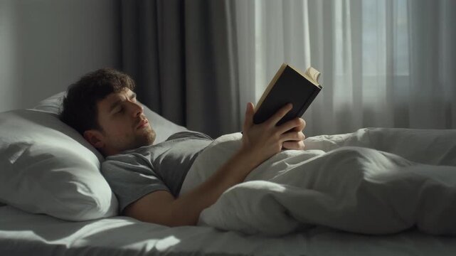 Reading but Not Moving. Bed Rotting. Lifestyle & Mental Health. A photorealistic medium shot of a person lying in bed holding an open book while staying under blankets all day
