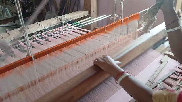 Handloom weaver in India working in her loom.	