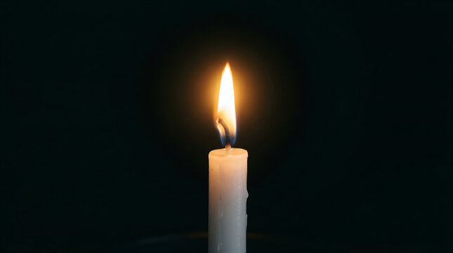 A single white candle burning brightly against a solid black background, symbolizing hope