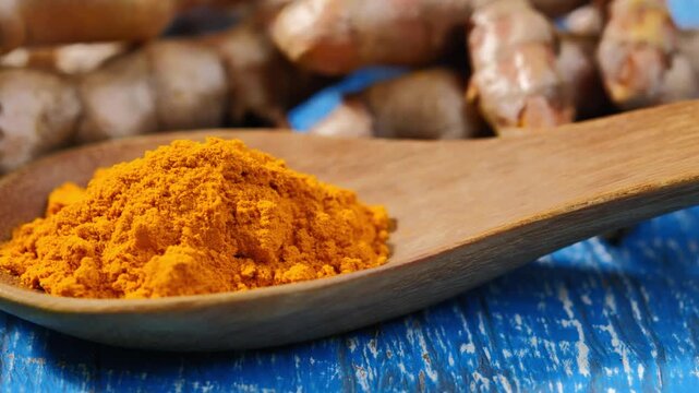 Turmeric powder in a wooden spoon