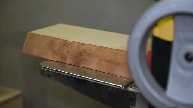 Closeup of carpenter man shaping wooden block on planer thicknesser jointer machine in workshop. Woodworking process, furniture preparation, handmade craftsmanship, precision tools, carpentry studio