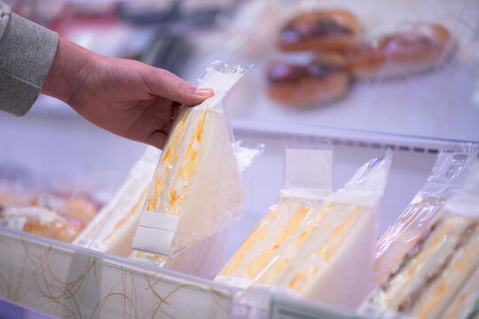 サンドイッチを選ぶ買い物客の手元