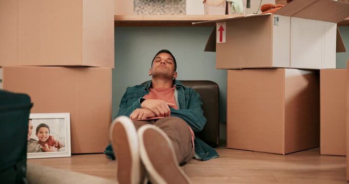 Moving, sleeping and tired with man in new home for property, real estate and investment. Fatigue, relax and dreaming with person and boxes in living room for future, exhausted and mortgage