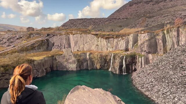 A Woman Gazing at the Hidden Dali&rsquo;s Hole Waterfall in Dinorwic Slate Quarry, Snowdonia National Park, Llanberis, Wales, UK