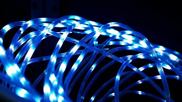 Curved bundle of blue LED network cables glowing