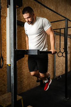 Man doing tricep dips on parallel bars at gym