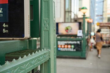 Fototapeta premium Close up of green metal railing at Broadway Lafayette subway entrance in Manhattan. Shallow depth of field shows New York City urban transportation background.
