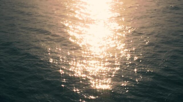 Sparkling evening sea waves with golden light reflection