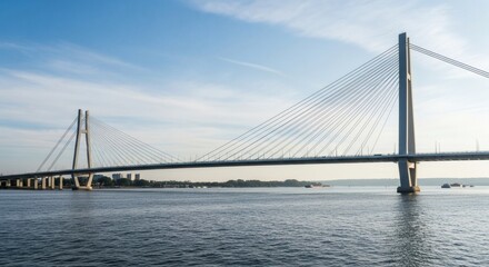 Obraz premium Cable stayed bridge over water with cityscape and blue sky background