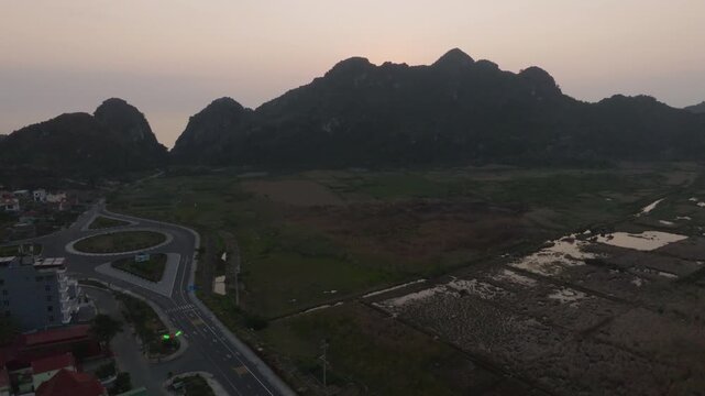Cat Ba Vietnam aerial view of town, roads, and karst hills with distant bay and islands appearing through haze.