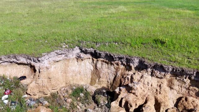 Low drone pullback reveal of weathered and eroded landscape after heavy rainfall