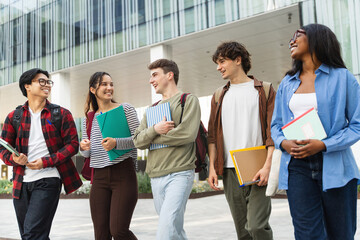 Multicultural friends walking together, enjoying student life in modern university campus