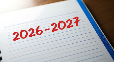 Fototapeta premium A notebook with the years 20262027 written on a piece of paper
