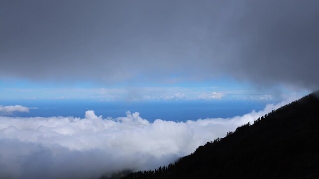 Thick cloud layer covering Tenerife landscape during storm Therese, ocean visible above clouds, dramatic weather and atmospheric mountain scenery