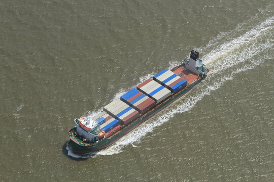 High-angle aerial shot of the feeder container ship "MTT DUMAI" transporting cargo across the ocean.