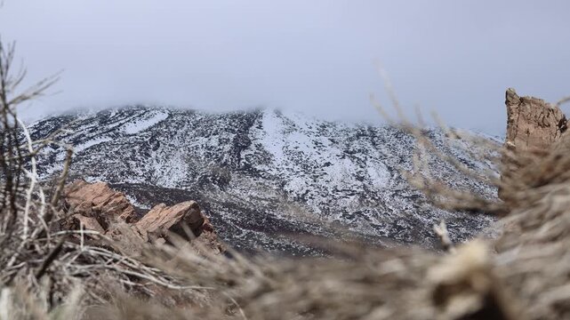 Snow covered Teide volcano landscape after storm Therese in Tenerife Canary Islands, dramatic clouds, volcanic terrain and winter conditions in subtropical island