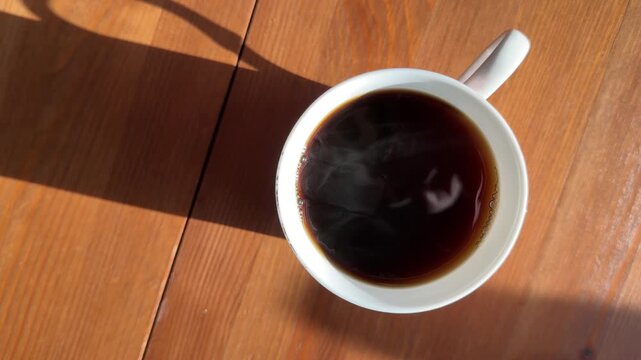 a cup of hot chicory on a wooden table with steam. close-up, shot from above. fletlay