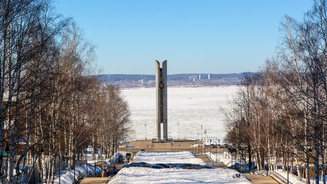 A view of the ice-covered Izhevsk Pond with the esplanade and the Friendship of Nations monument on a clear spring day.