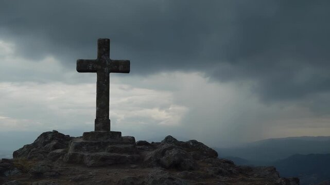Ancient stone cross monument atop a rocky peak overlooking a vast mountainous landscape at dusk, symbolizing faith and resilience.