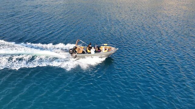 Aerial drone top down tracking video of small inflatable rib speed boat cruising in mediterranean sea