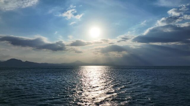 Aerial drone cinematic video of sunset over cloudy open ocean sea with beautiful colors