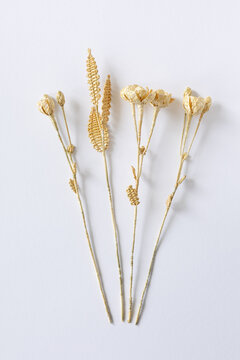 Three flowers are made of straw on a white background