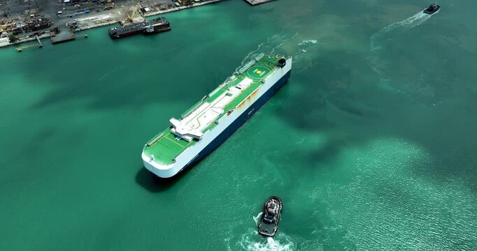 Large Vehicle Carrier Ship Maneuvers Into Tropical Harbor With Assistance From Support Tugboats For Maritime Logistics And Global Supply Chain Operations