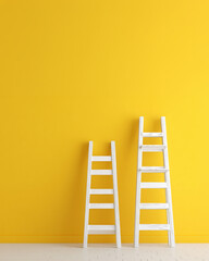 Two white wooden ladders leaning against a yellow wall.