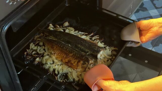a girl puts fish in the oven to bake. mackerel with onions. dietary food. cooking baked fish.