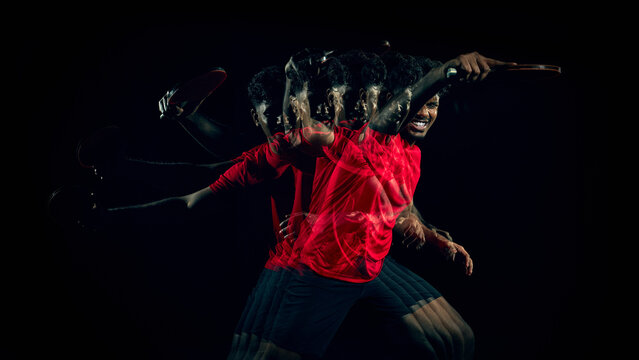 Table tennis player with stroboscopic motion in wide dark studio composition with copy space. Concept of creative banner design, motion advertising, performance visuals and dynamic layout usage.